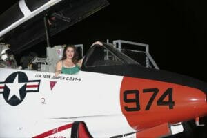 Female sitting in a Navy Jet on the USS Midway for a photo printed onsite by proimagesphoto