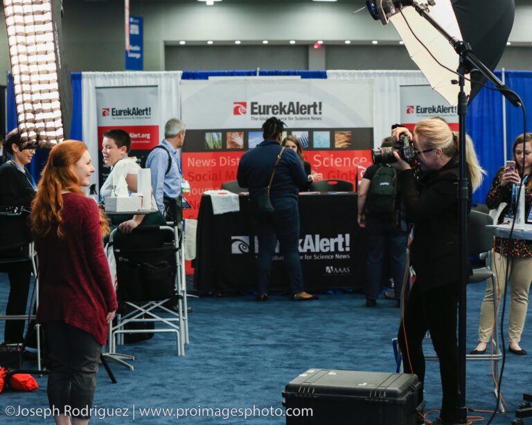 Headshot station at the AAAS Annual Meeting in Austin, photographer posing an attendee on the exhibit floor