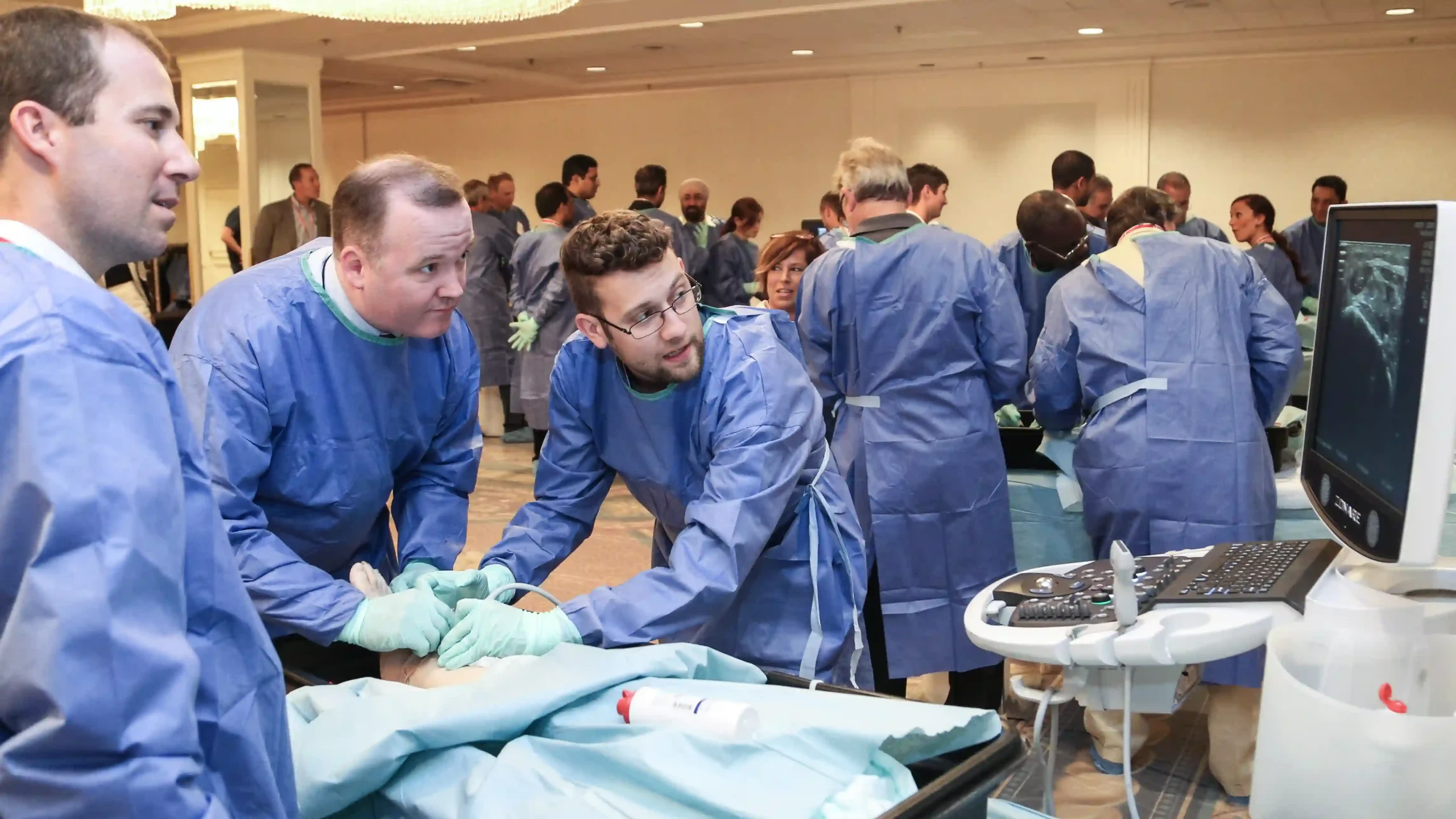 Medical conference photographer capturing a hands-on ultrasound training workshop with physicians practicing on a simulation model