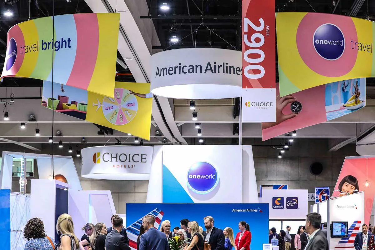 San Diego convention expo photography capturing vibrant American Airlines and oneworld banners above a busy crowd.