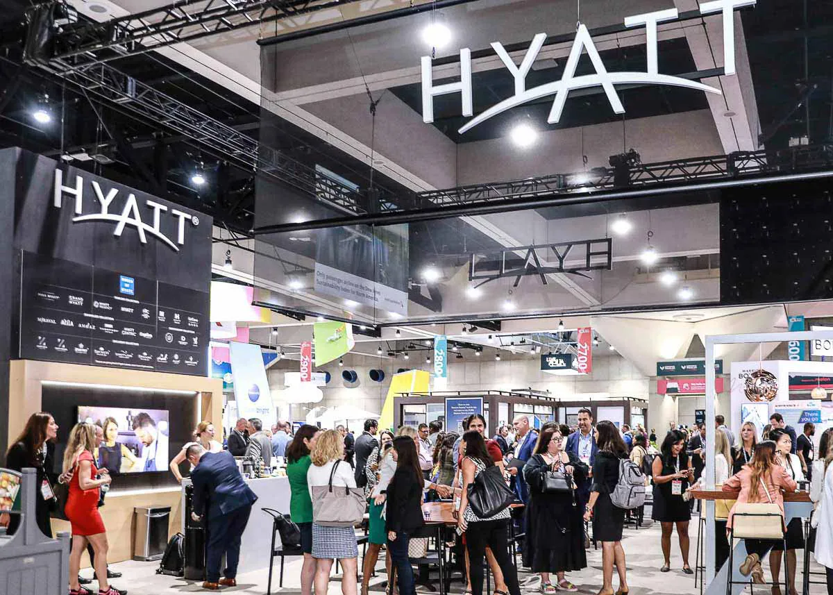Hyatt corporate expo photography capturing a large crowd of convention attendees gathered beneath major venue branding.