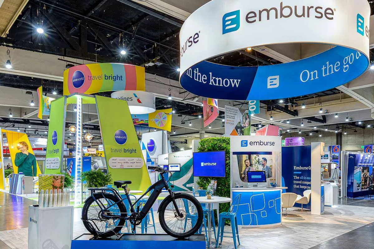 San Diego corporate convention photography capturing a custom branded Emburse exhibit booth on a busy trade show floor.