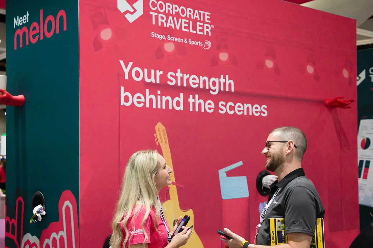 Full-day tradeshow booth photographer in San Diego capturing Corporate Traveler staff engaging attendees.