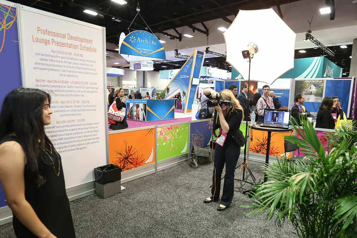 Photographer shooting attendees at a sponsored LinkedIn headshot lounge in San Diego, a turnkey headshot station we run for exhibitors across the country