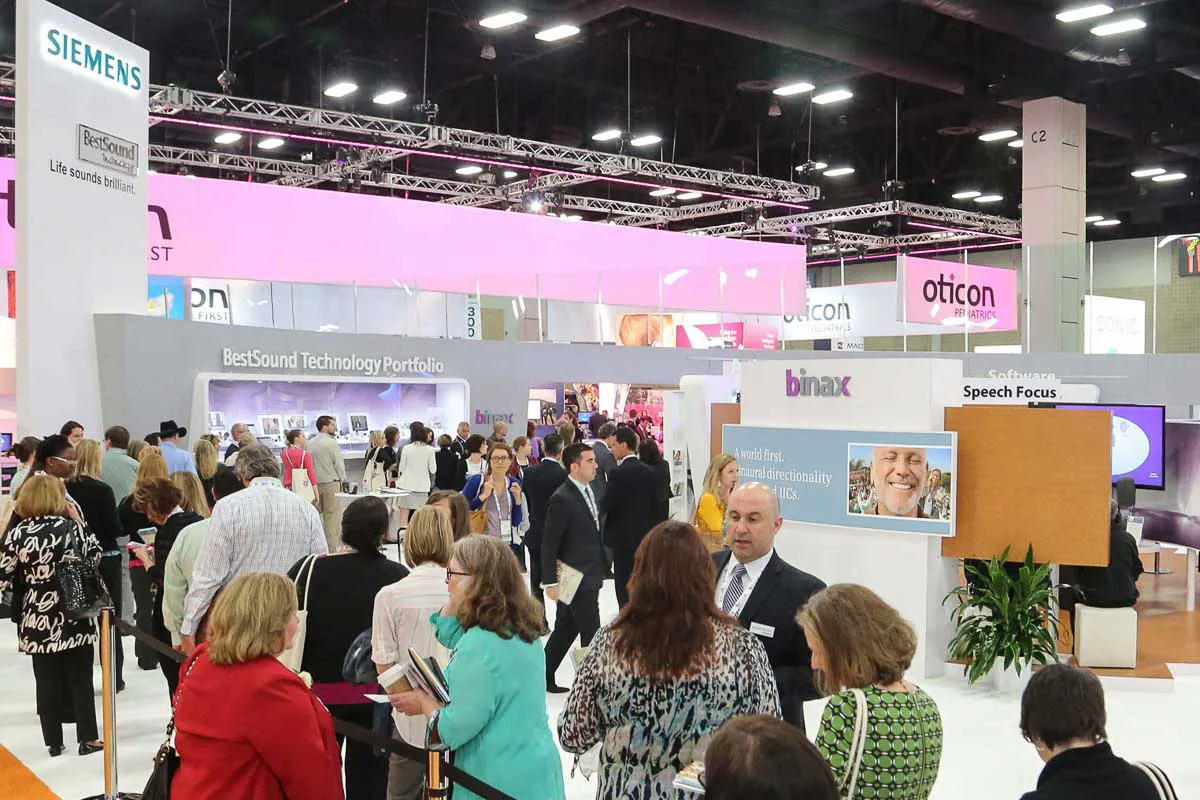 San Diego convention expo photography capturing a busy crowd of attendees queued at a Siemens corporate trade show booth.