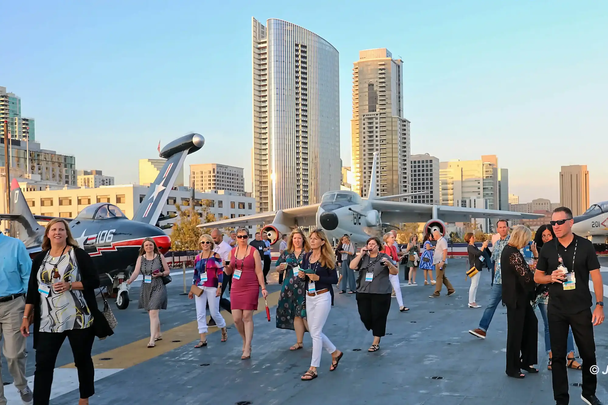San Diego corporate reception photography capturing convention attendees on the USS Midway Museum flight deck at sunset.